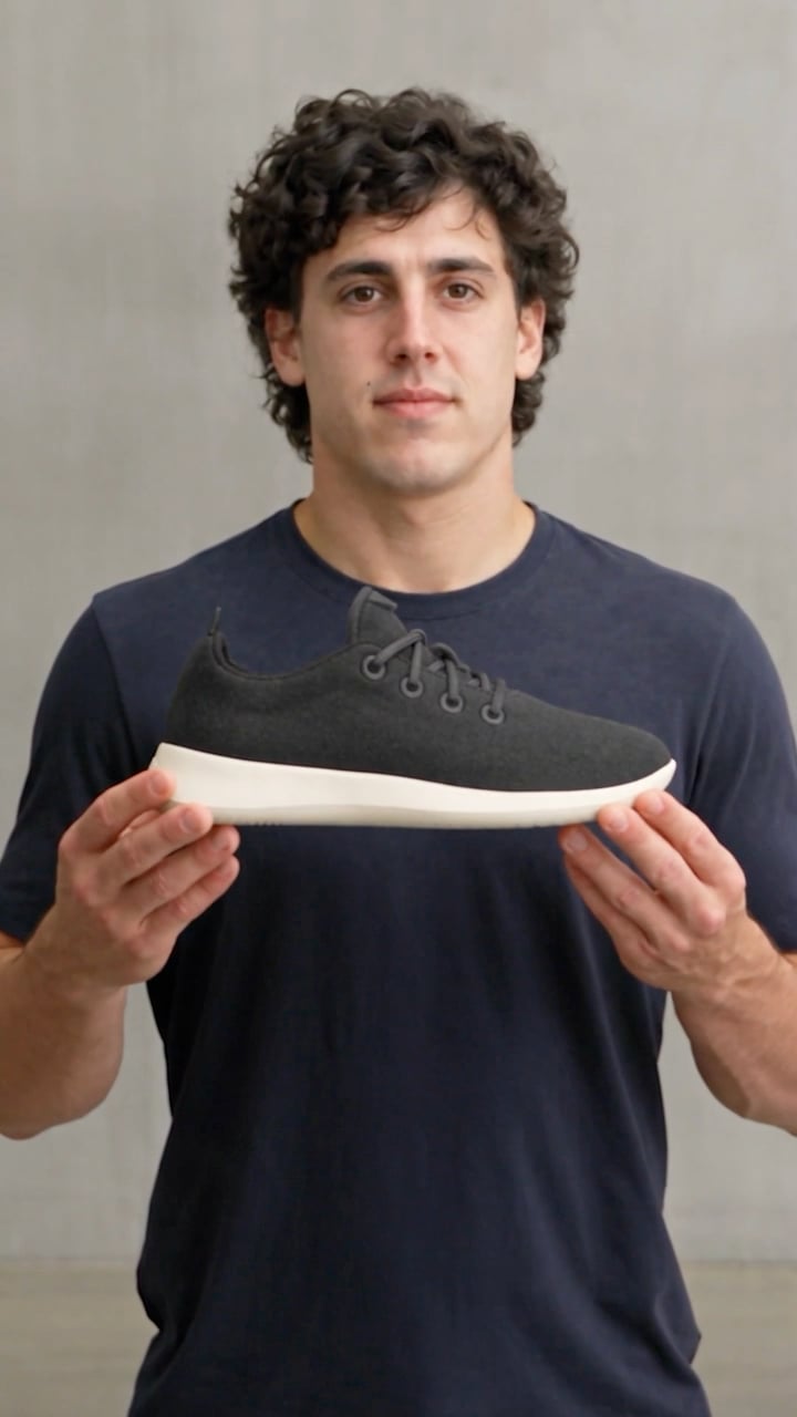 Presenter holding a black wool sneaker